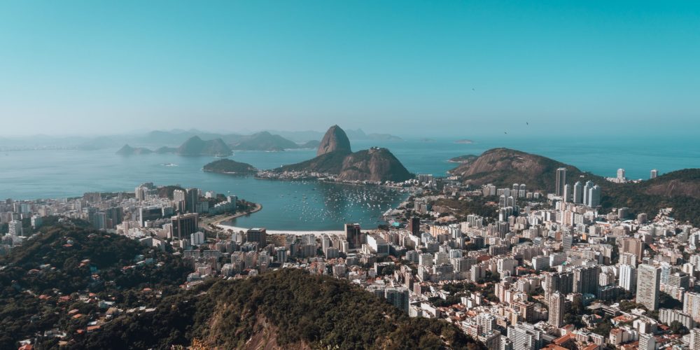A landscape of Rio De Janeiro surrounded by the sea under a blue sky in Brazil